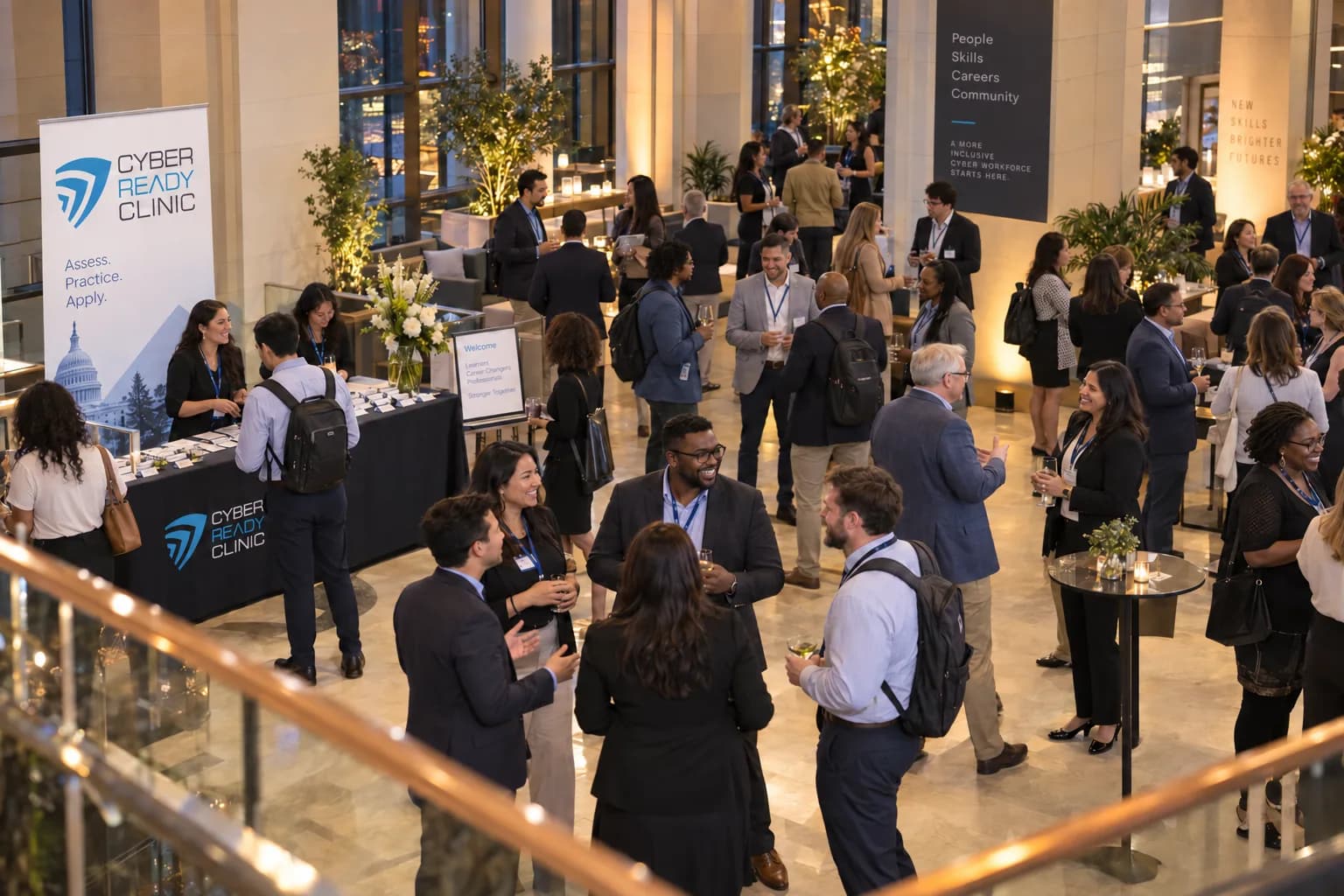 Cyber Ready Clinic practitioners and alumni talking in small groups at an evening networking reception, a Cyber Ready Clinic banner reading “Assess. Practice. Apply.” standing at the left.